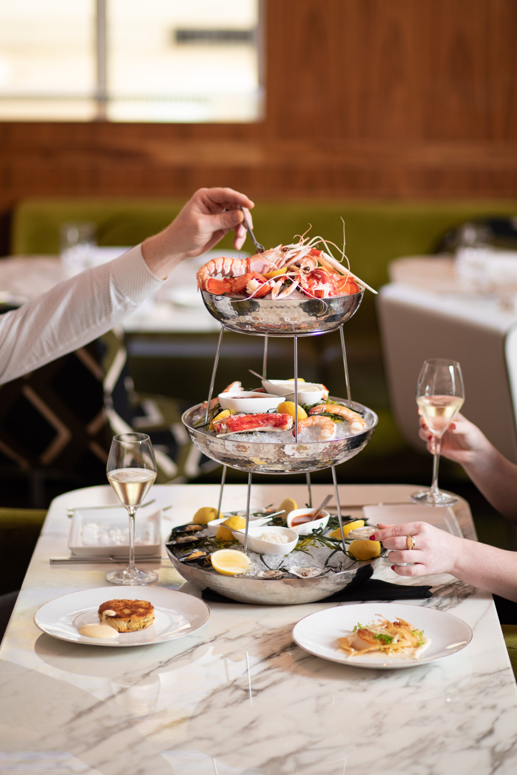Couple enjoying wine and the Barclay Prime Grand Plateau (chef's selection of raw bar and seafood cocktail)
